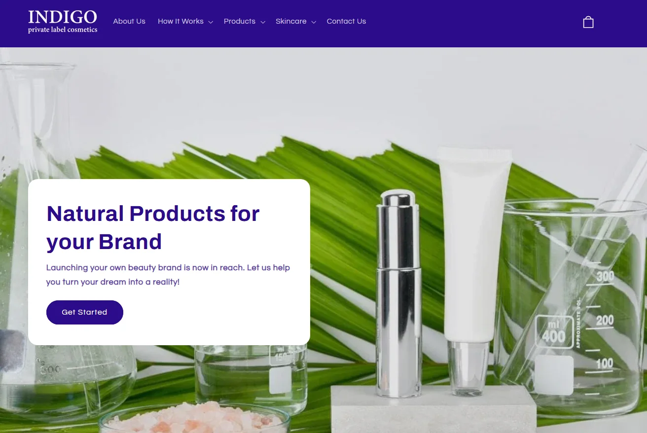 Skincare products including a silver bottle and white tube next to glass beakers with green leaves in the background.